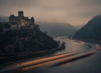 Die Marksburg auf einem Hügel über dem Rhein in der Abenddämmerung mit nebligem Tal