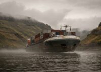 Rhein-Frachtschiff durchquert das enge Mittelrheintal beladen mit Containern
